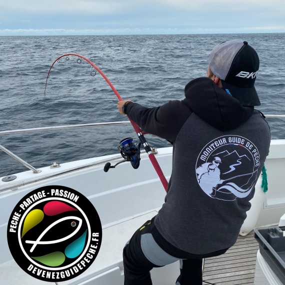 Raph Fishing, Moniteur guide de pêche Corse en train de pêcher en mer depuis un bateau avec un poisson au boit de la ligne