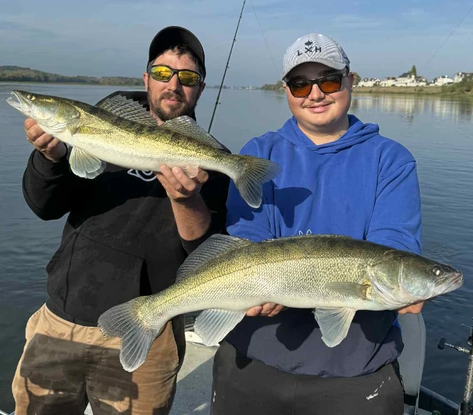 Florian Berthonneau moniteur-guide de pêche avec un client et deux sandres